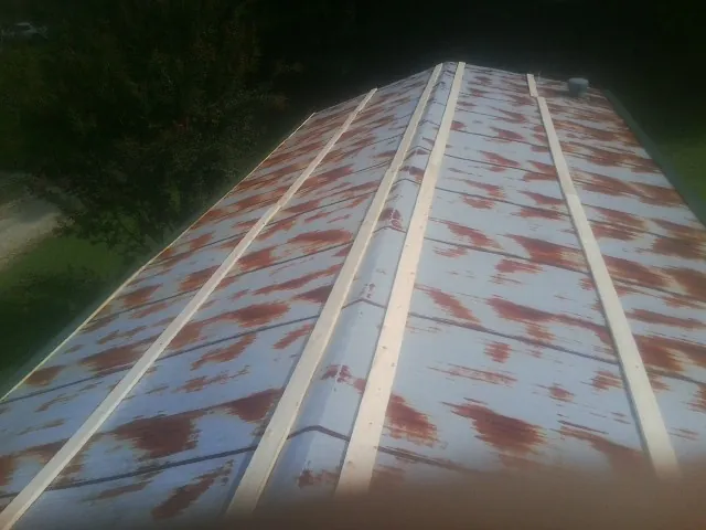 Rusted metal roof panels with new wood purlins before replacement — Storm Damage Roof Repair in Merrimac by Roofing Brothers