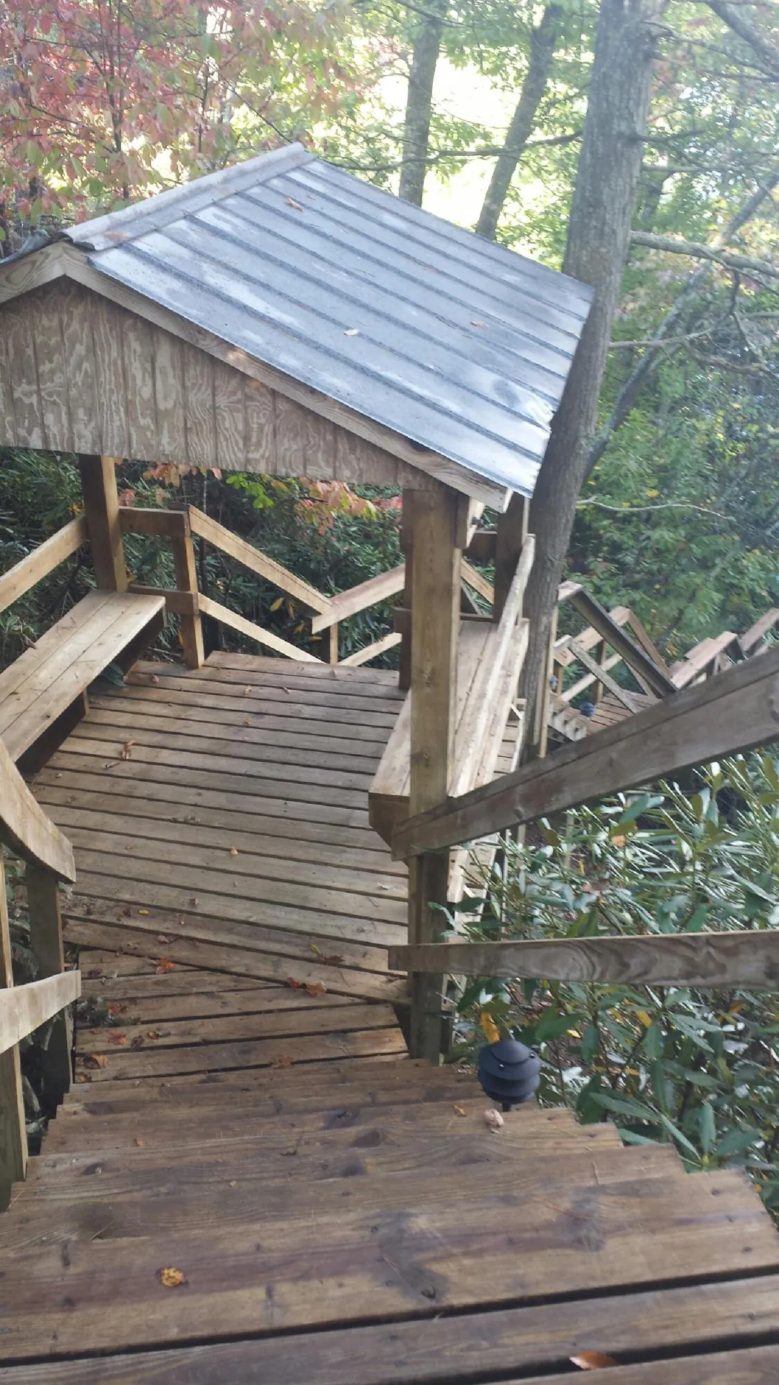 Metal roofed shelter over wooden steps on a wooded walkway — Skylight Repair & Installation work by our crew in Merrimac